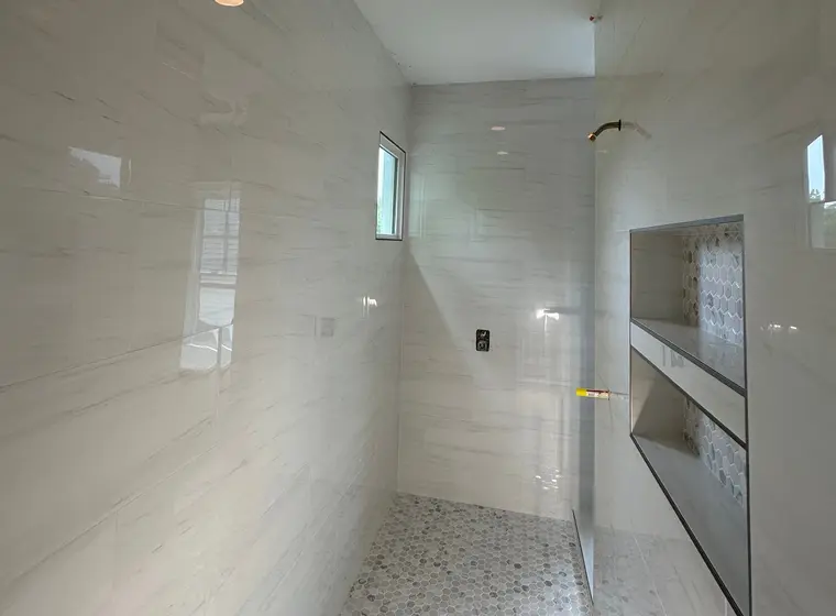 Porcelanato gran formato tipo mármol en piso y muros de ducha