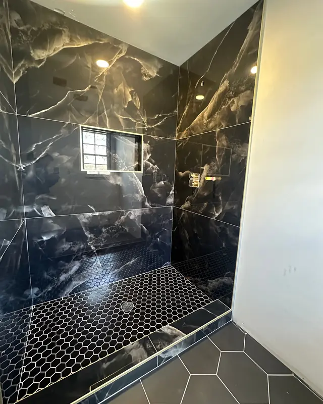 Ducha en porcelanato tipo ónix negro con vetas doradas y piso de mosaico hexagonal, Atlanta