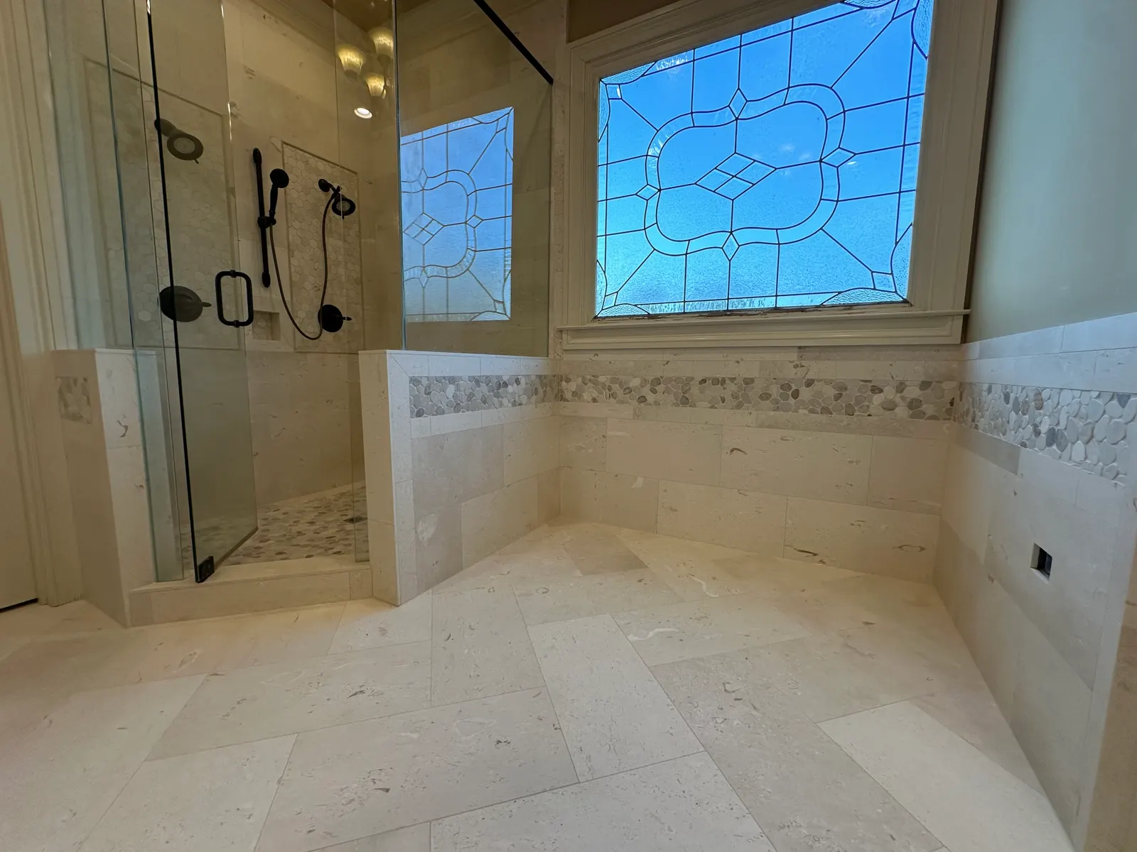 Limestone-look shower beside leaded stained-glass windows, Atlanta GA